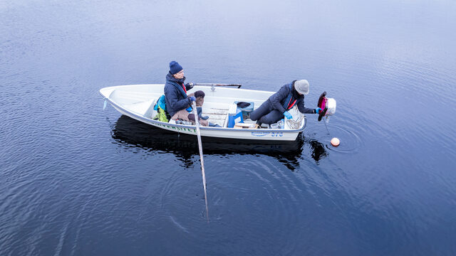 Researchers collecting samples from a boat
